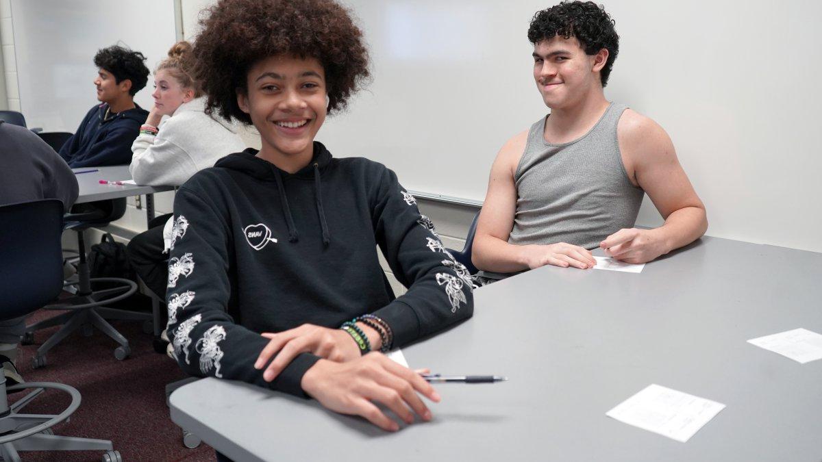 two students smiling at a table